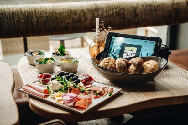 Gemütlicher Frühstückstisch mit einem Tablet auf dem ein Spiel läuft.